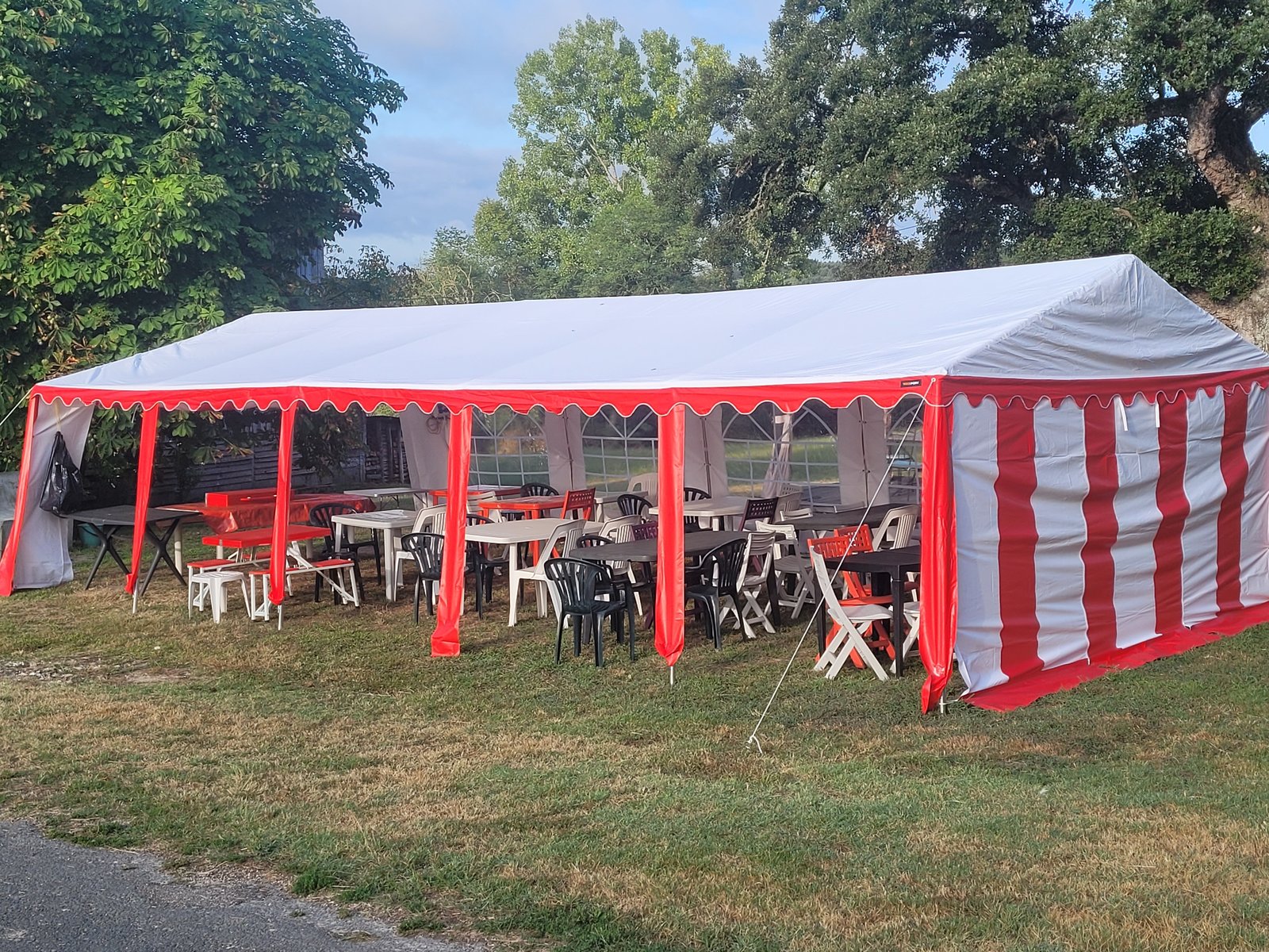 Intérieur du chapiteau aménagé pour une réception avec tables et chaises