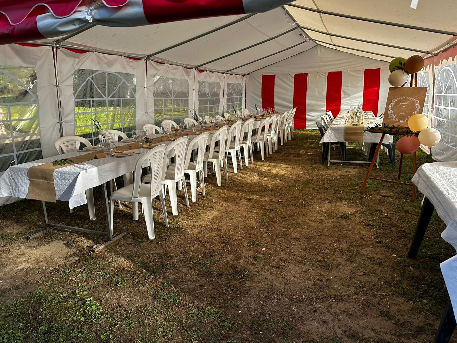 Grande tablée dressée sous le chapiteau pour un repas de fête